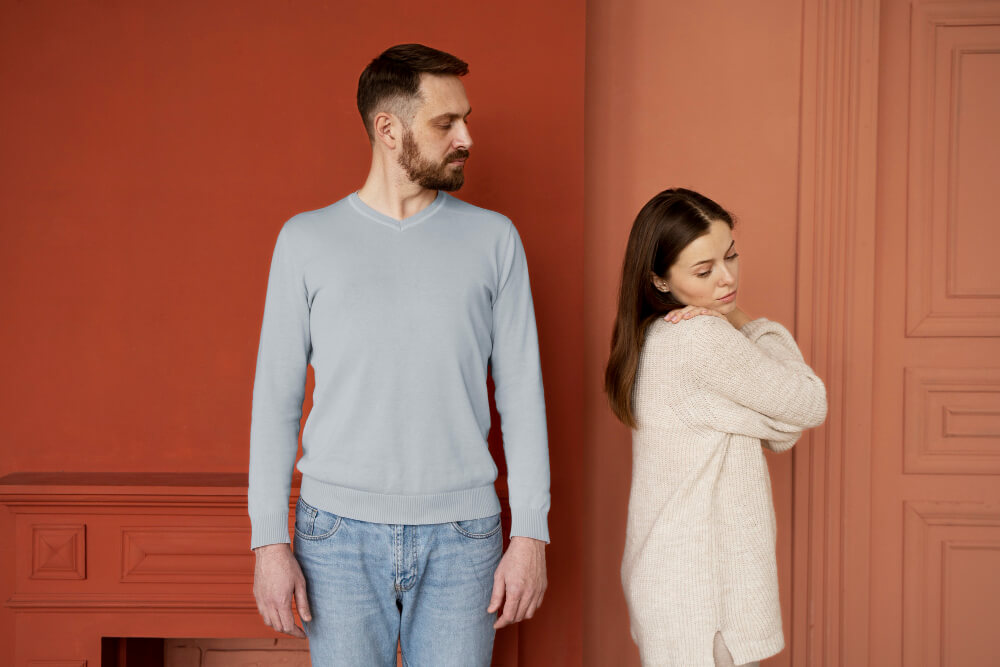 Couple standing apart and looking away, symbolizing emotional distance and lack of connection in a relationship